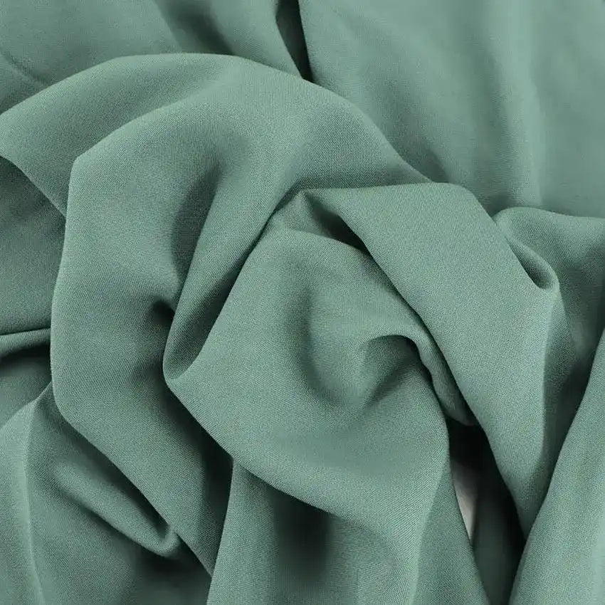 Tissu vert sauge doux avec des plis et des froissements délicats.